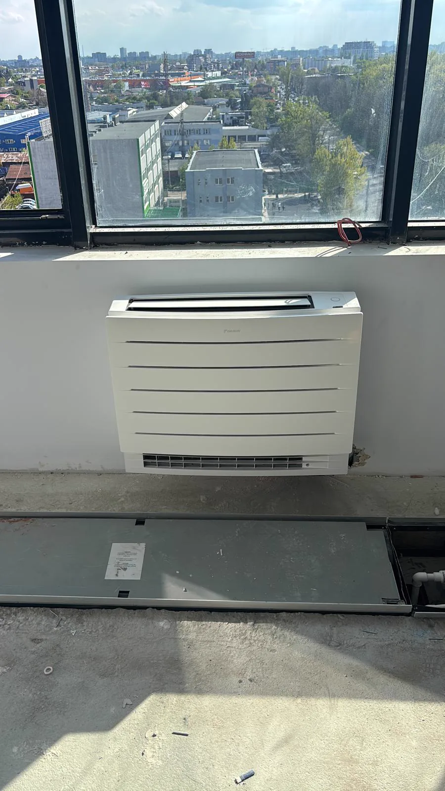 Aparat tip consola Daikin instalat intr-un spatiu comercial cu ferestre mari